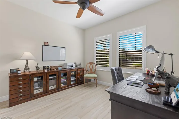 Office space with light wood-type flooring and ceiling fan