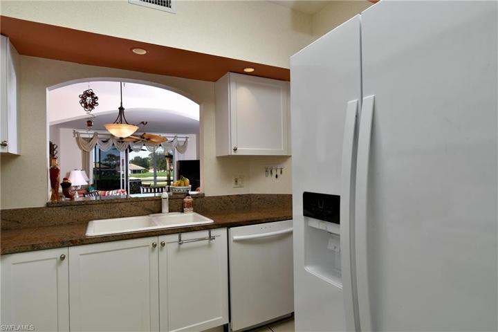Pass through from kitchen into dining living area and out to lanai with a view of the 9th green.