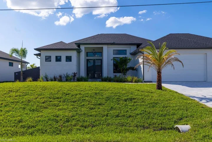 View of front of home featuring a garage and a front yard