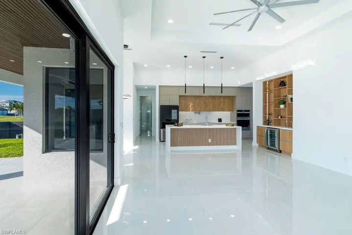 Kitchen featuring pendant lighting, beverage cooler, a raised ceiling, and sink