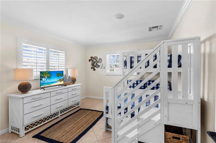 Bedroom with crown molding and light tile patterned floors