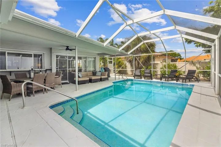 View of swimming pool featuring a lanai, an outdoor hangout area, a patio area, and ceiling fan