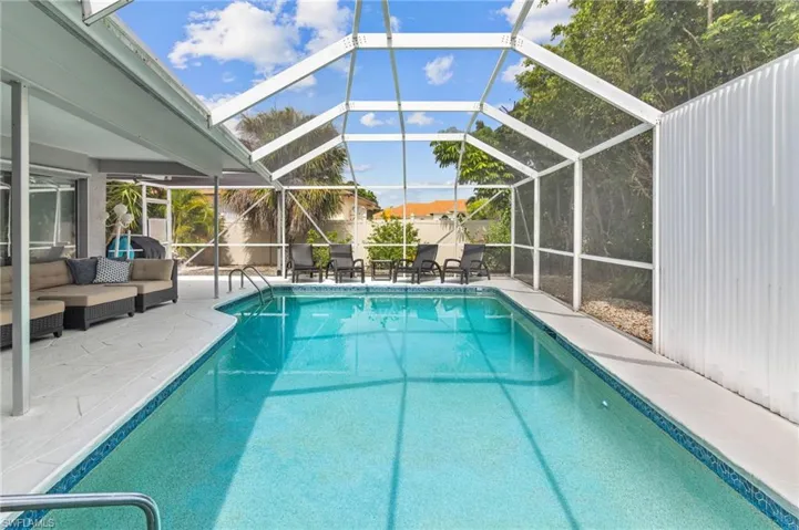 View of swimming pool with a patio, an outdoor living space, and a lanai