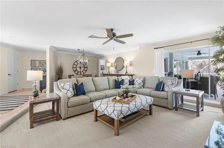 Living room with ceiling fan and ornamental molding