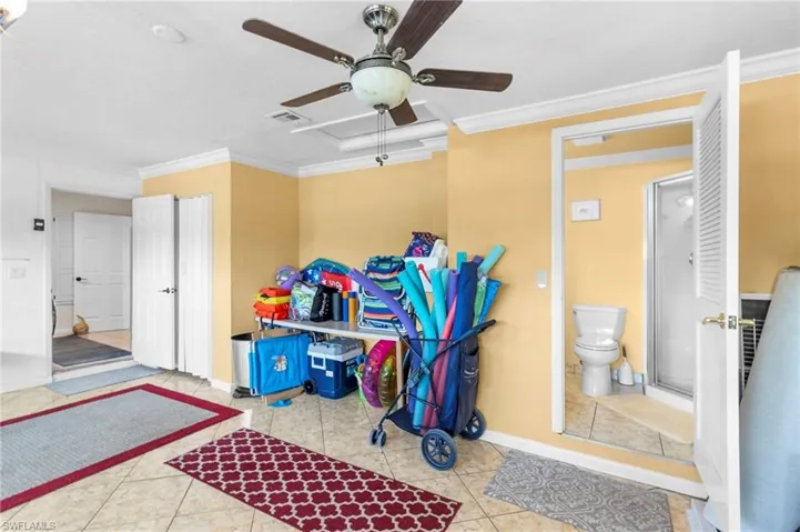 Misc room with ornamental molding, tile patterned floors, and ceiling fan