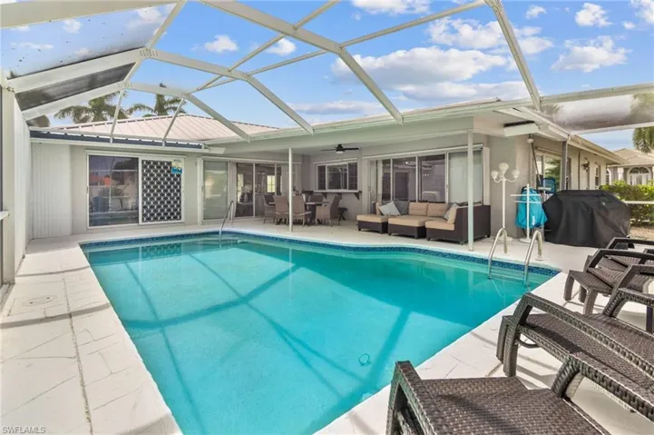 View of swimming pool with an outdoor living space, a patio, a lanai, and area for grilling