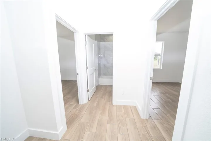 Corridor with light hardwood / wood-style flooring