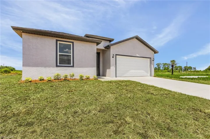 View of front of property featuring a garage and a front yard