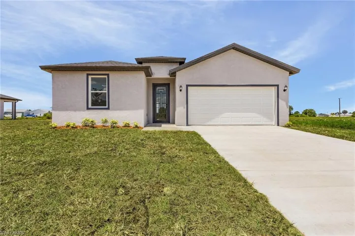 View of front of home with a garage and a front lawn