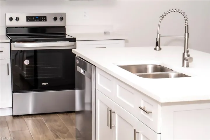 Kitchen featuring white cabinets, hardwood / wood-style floors, appliances with stainless steel finishes, and sink
