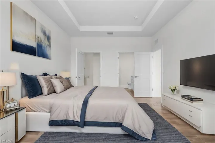 Bedroom featuring light hardwood / wood-style floors and a raised ceiling