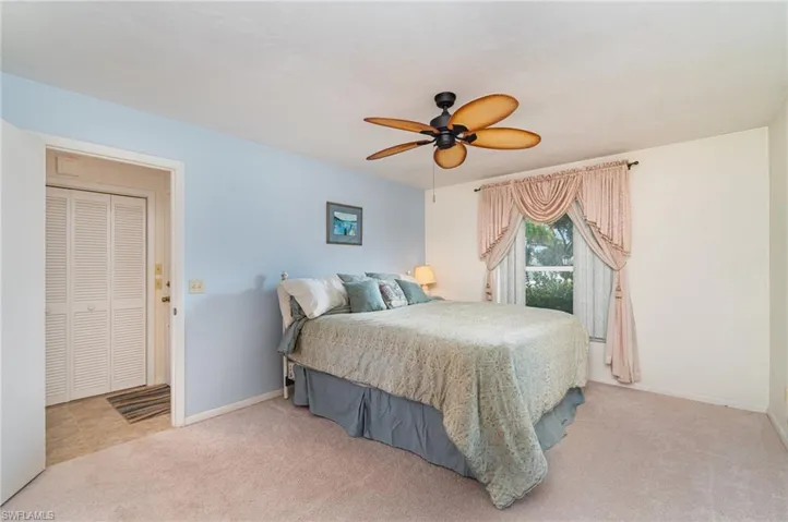 Bedroom with light colored carpet and ceiling fan