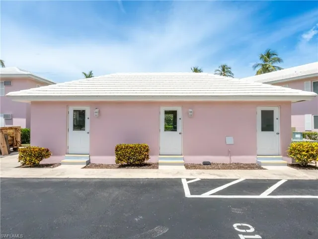View of front of property featuring stucco siding, a tile roof, and uncovered parking