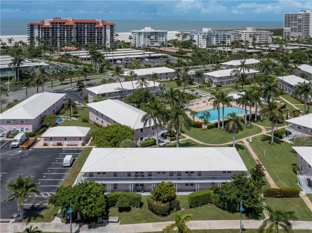 Drone / aerial view of a nearby body of water and a pool