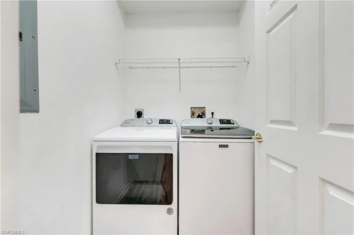 Dedicated laundry alcove with overhead shelving