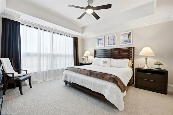 Spacious Primary Bedroom with tray ceiling and ceiling fan