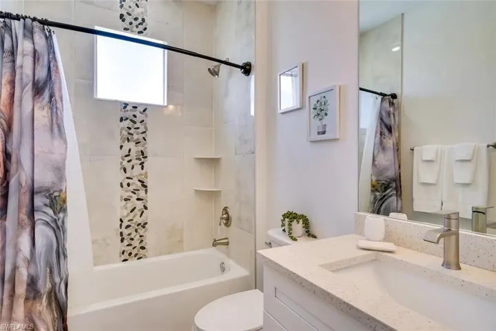 Full bathroom featuring shower / bath combo, toilet, and vanity