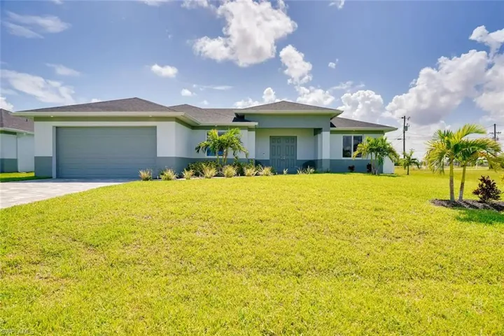 Ranch-style home featuring a garage and a front yard