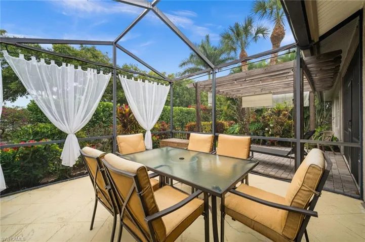 View of patio featuring a sunroom, a lanai, and outdoor dining area