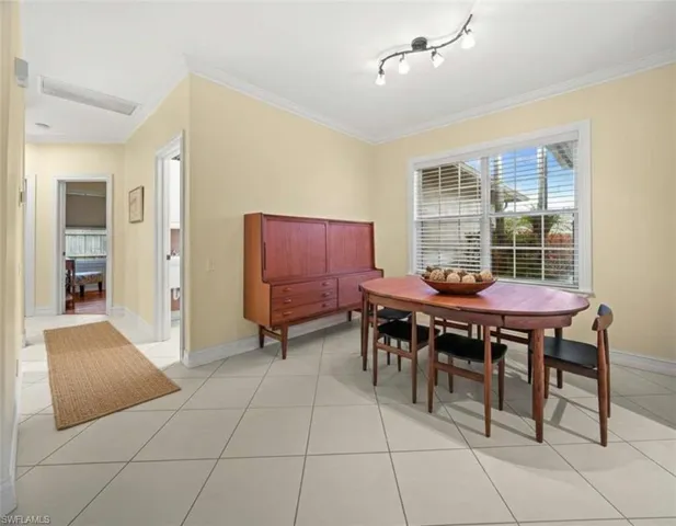 Dining area featuring crown molding and light tile patterned floors