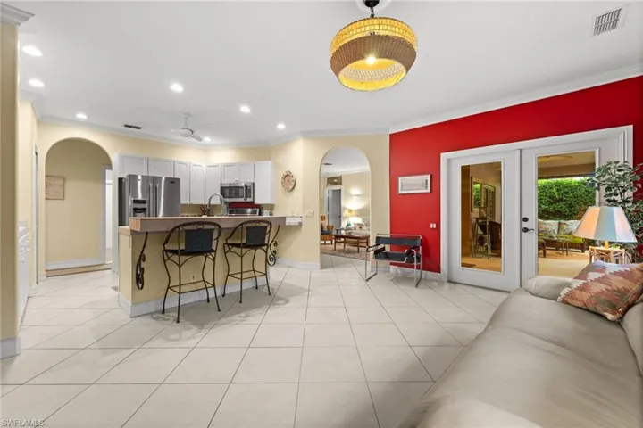 Kitchen featuring arched walkways, ornamental molding, a kitchen breakfast bar, a peninsula, and ceiling fan