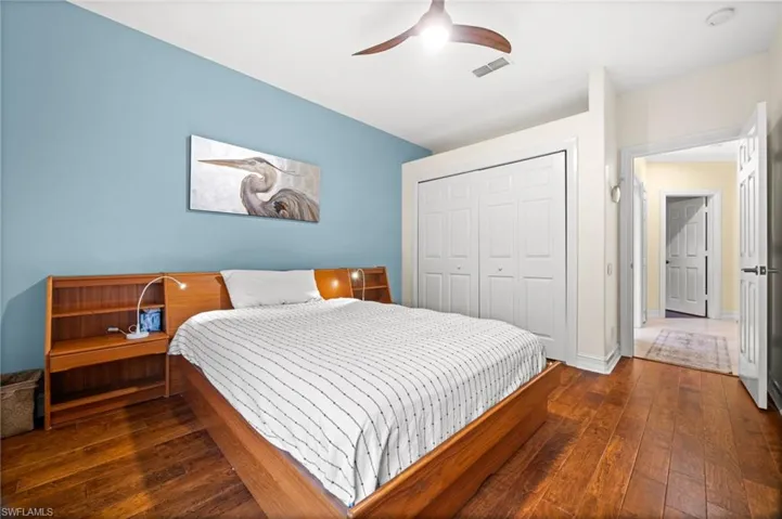 Bedroom with dark wood-type flooring, a closet, and ceiling fan