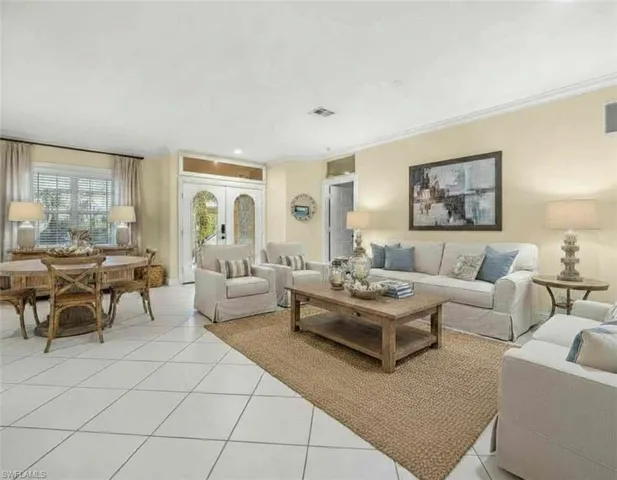 Living room with light tile patterned floors, french doors, ornamental molding, and recessed lighting