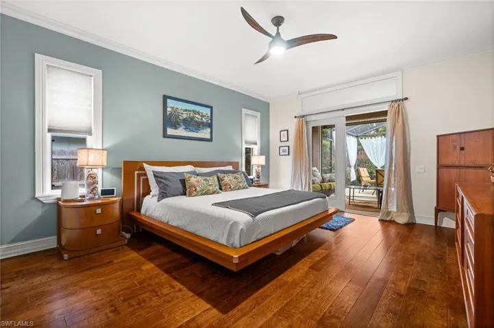 Bedroom with access to outside, ceiling fan, dark wood-type flooring, and ornamental molding