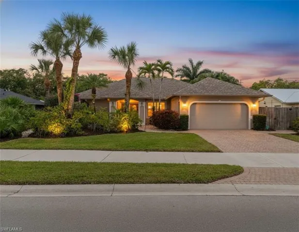 Ranch-style home with decorative driveway, a garage, and stucco siding