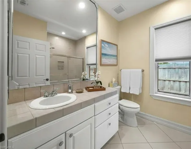 Full bathroom featuring vanity, light tile patterned flooring, a shower stall, and recessed lighting