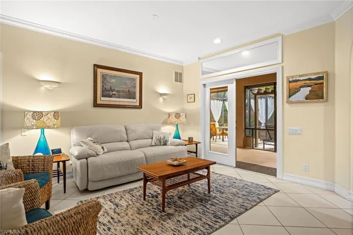 Living room with crown molding, light tile patterned floors, and recessed lighting