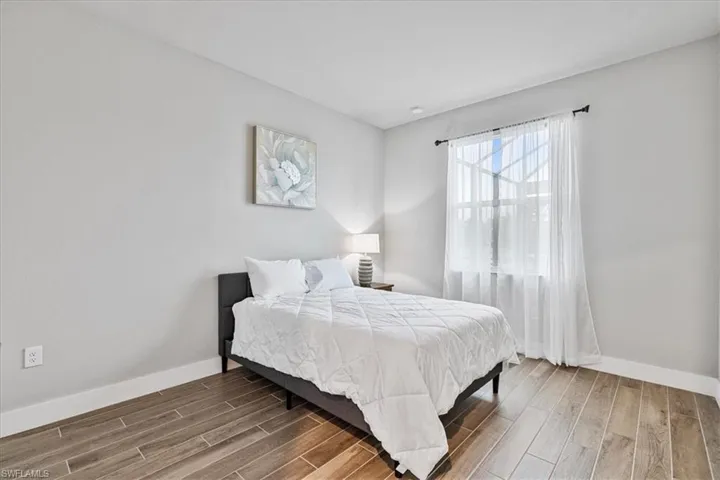 Bedroom with wood finished floors and baseboards