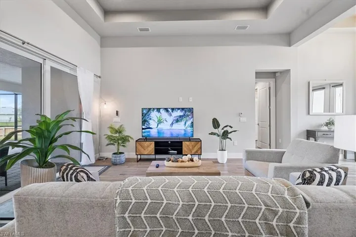 Living area with wood finished floors and a raised ceiling