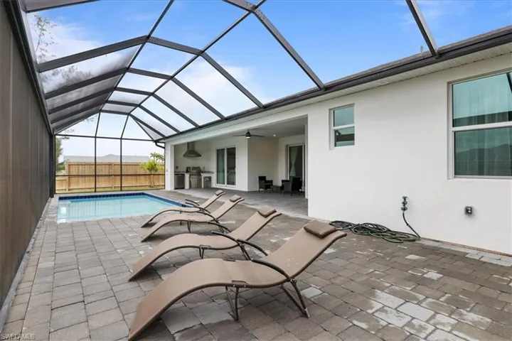 View of swimming pool with a ceiling fan, a patio area, and a lanai