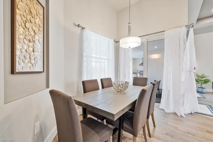 Dining room with light wood-style flooring and a high ceiling