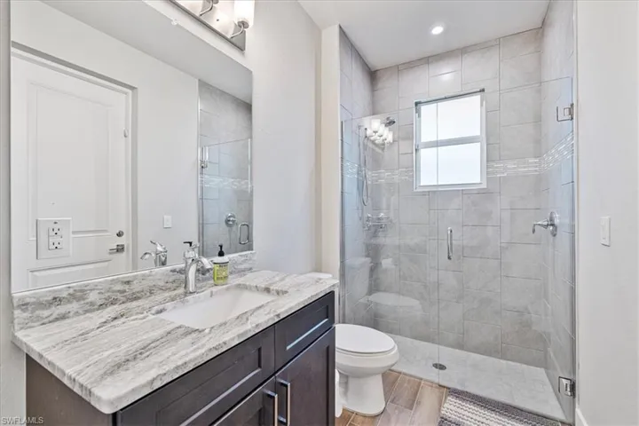 Bathroom with vanity, a shower stall, and wood finished floors