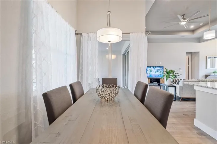 Dining area with a ceiling fan, wood finished floors, and healthy amount of natural light