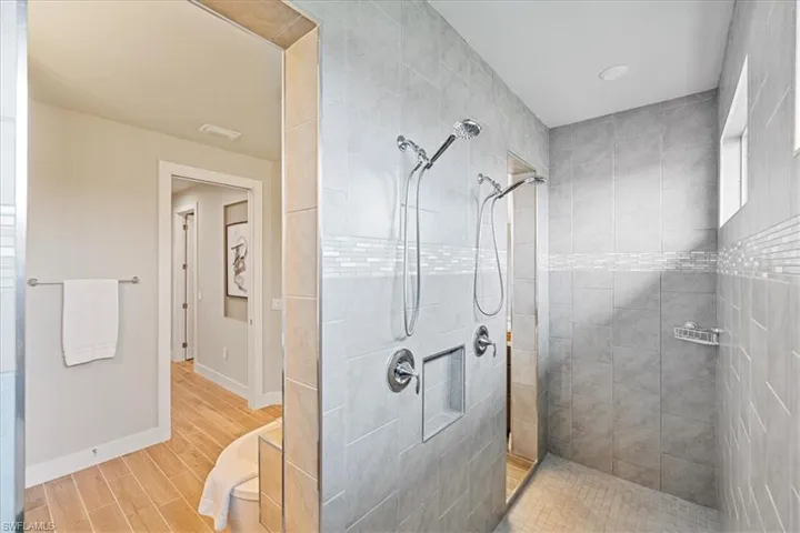 Full bath featuring a walk in shower and wood finished floors
