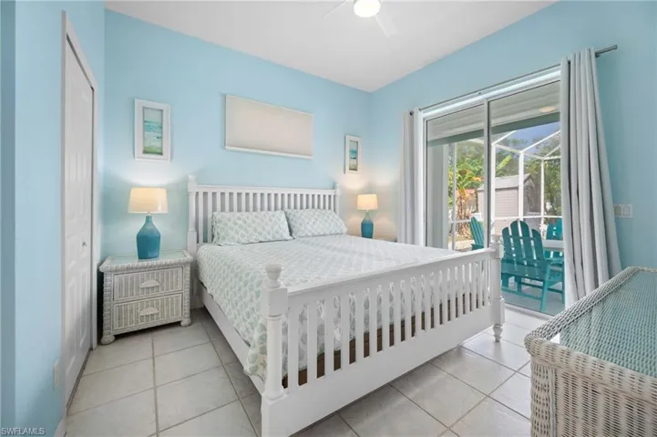 Tiled flooring, white ceiling fan, sliding glass doors, and a screened outdoor patio