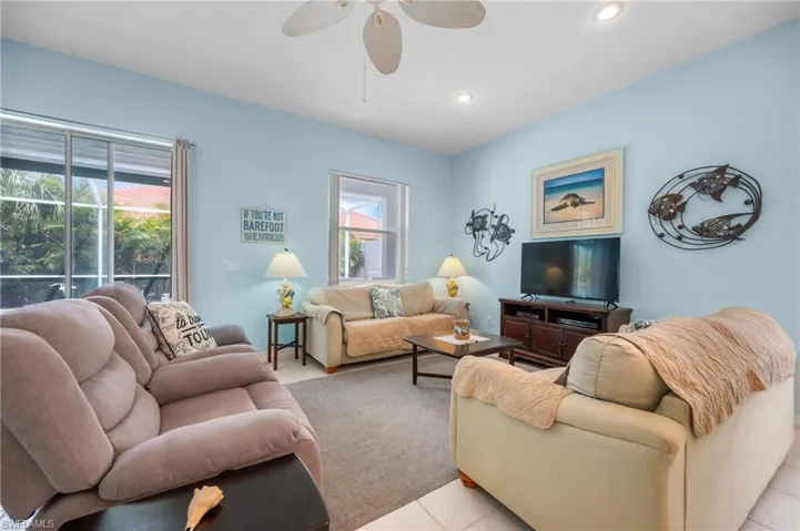 Recessed lighting, ceiling fan, tile flooring, window with exterior scenery, and a sliding glass door