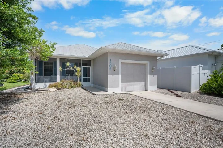 Screened front porch, metal roof, attached garage, concrete driveway, privacy fence