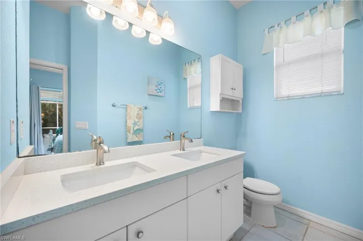 Double vanity with white cabinetry, dual undermount sinks, and a light-colored countertop