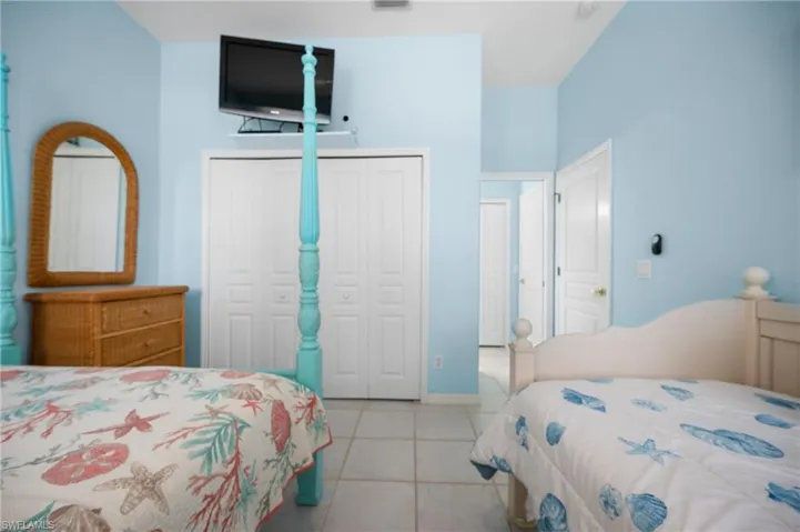 Vaulted ceiling room with ceramic tile flooring, bi-fold closet doors, and recessed doorway