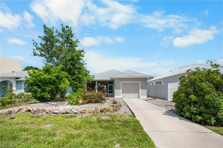 Single-story residence featuring a screened entry, attached garage, and metal roof