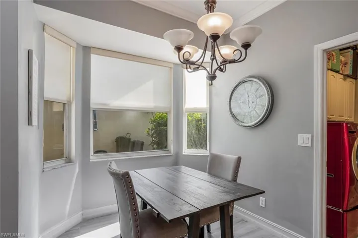 Dining space with washer / dryer, a chandelier, and ornamental molding