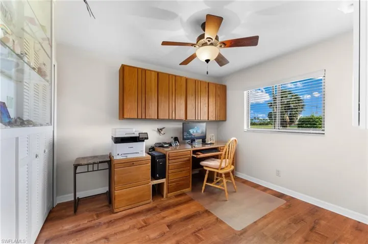 Secondary bedroom currently being used as a home office featuring ceiling fan and hardwood / wood-style flooring