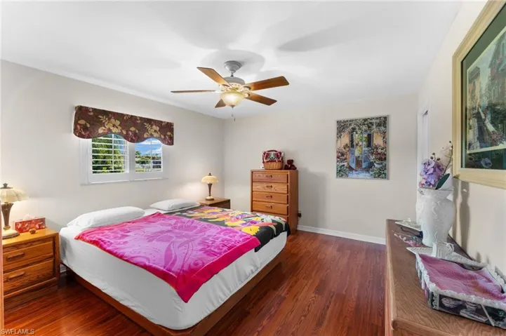 Master Bedroom with ceiling fan and dark hardwood / wood-style floors and plantation style shutters