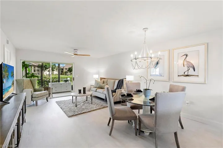 Dining room featuring ceiling fan with notable chandelier and light wood-type flooring