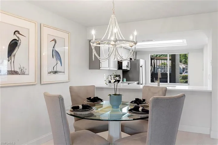Dining area with sink, a chandelier, and light hardwood / wood-style flooring