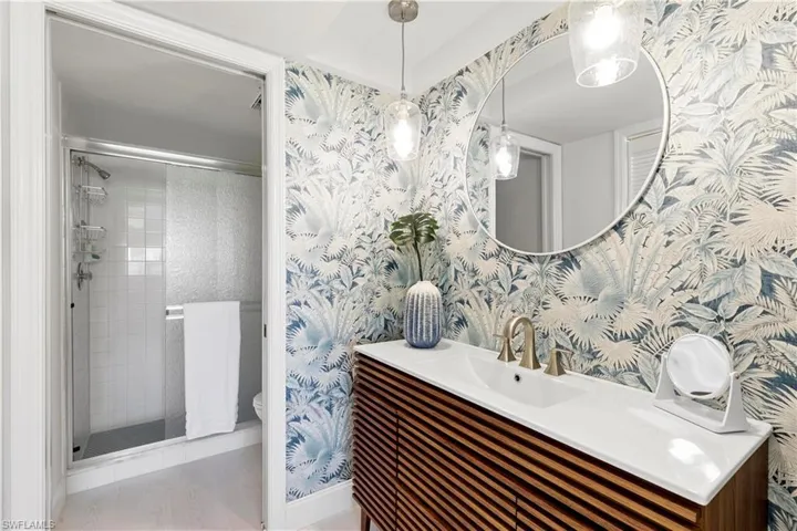 Bathroom with a shower with shower door, vanity, and toilet